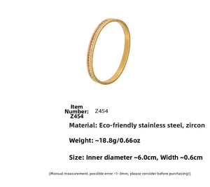 Detail of gold stainless steel bangle with zircon inlay, width 6mm and 60mm inner diameter