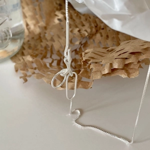 Minimalist 925 sterling silver geometric pendant necklace on craft paper background