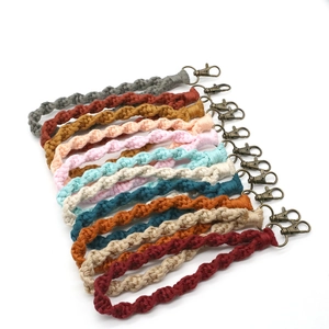Vista piana di braccialetti in macramè colorati con chiusure a moschettone in bronzo