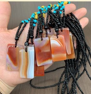 Close-up of rectangular carnelian agate pendants with natural patterns and beaded necklaces