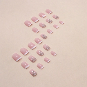 Short square pink press-on nails with white French tips and delicate floral patterns