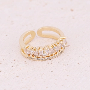 Detail of gold double-layered open ring with rectangular zircons on textured stone