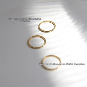Detailed view of three minimalist 18K gold-plated stackable rings with black crystal accents