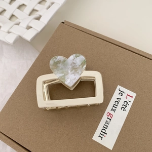 Dettaglio del fermaglio a rettangolo crema con decoro a cuore in acetato marmorizzato