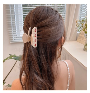 Chic beige acetate hair claw with cherry pattern shown on a woman's hair in detail