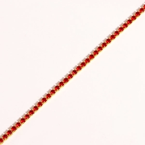 Macro detail of red cubic zirconia bracelet with gold claw setting on white background