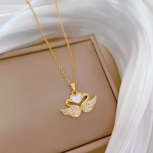 Elegant gold titanium swan necklace with crystals and shell inlay on silk background