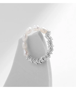 Macro detail of S925 sterling silver ring with irregular white pearls on grey stand