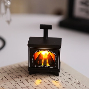 Close-up of mini LED fireplace lamp with warm orange glow on vintage paper background