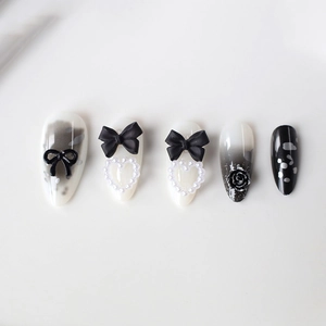 Faux ongles amande avec nœuds noirs, perles et roses 3D sur dégradé monochrome
