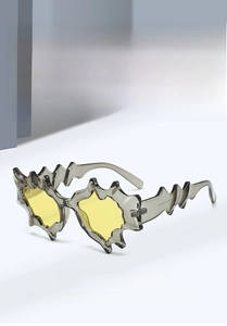Close-up of irregular wave frame sunglasses with yellow lenses and grey transparent finish