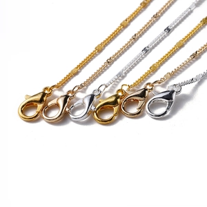 Detailed macro view of gold and silver DIY necklace chains with lobster clasps