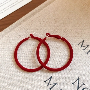 Close-up of vintage dark red flocked hoop earrings with a soft velvet texture finish