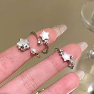 Elegant adjustable star ring with zircon and pearl accents on female hand model