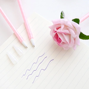 Creative pink rose artificial flower ballpoint pen with blue ink on a notebook