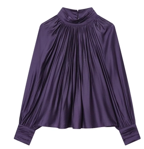 Dettaglio della camicetta di raso viola con elegante collo alto e pieghe radiali
