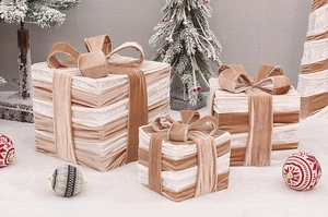 Detailed view of three velvet Christmas gift boxes with bows under a decorated tree