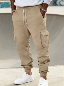 Close-up of khaki cargo joggers with side flap pockets and elastic drawstring waist