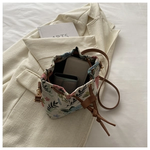 Top view of floral drawstring bucket bag with mobile phone and card holder inside