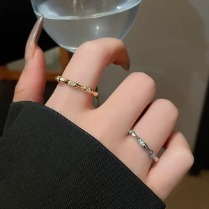 Detail of bamboo style rings with small zircons worn on hand for a minimalist aesthetic