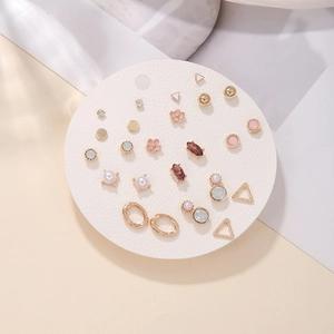 Close-up of a 12-pair gold earring set with pearls and crystals on a white display card