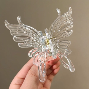 Vue détaillée d'une pince à cheveux papillon en acrylique avec ressort en métal doré