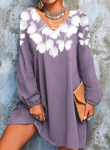 Detail of the V-neckline featuring elegant white floral patterns on a purple dress