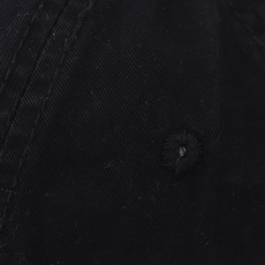 Macro-detail van de zwarte katoenen baseballcap met borduursels en zichtbare naden