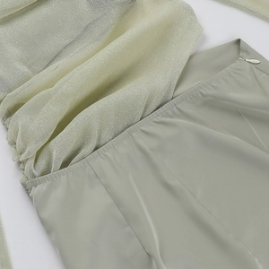 Close-up of sage green mesh splicing detail and side zipper on a long sleeve dress