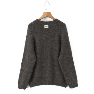 Detail of dark grey crewneck knit sweater showing fluffy mohair texture and neck label