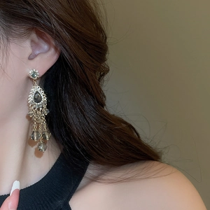 Close-up of bohemian tassel earrings with grey crystal teardrops and sparkling rhinestones