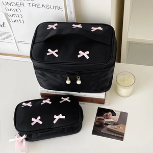 Detailed set of black cosmetic bags with pink bows and pearl zipper pulls