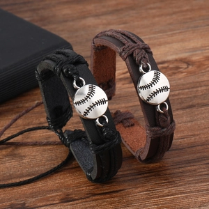 Detailed shot of black and brown braided leather bracelets with baseball charms on wood