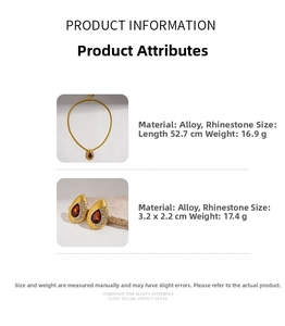 Detailed view of vintage gold snake chain necklace and rhinestone teardrop earrings