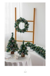 Makroaufnahme von nordischem gefrostetem Weihnachtskranz und Mini-Schneetannen im Set