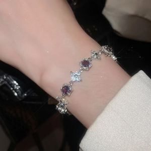 Close-up of elegant silver bracelet with purple floral zircon stones on a female wrist