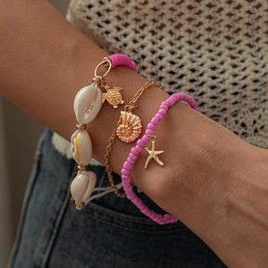 Detailed close-up of beach jewelry set with shell, turtle and starfish pendants on wrist