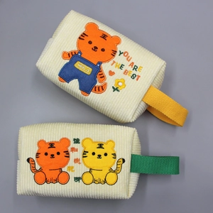 Makroaufnahme der Cord-Textur und Stickerei auf cremefarbenen Tiger-Taschen