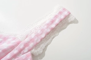 Close-up of pink and white plaid fabric with delicate white lace edge detailing