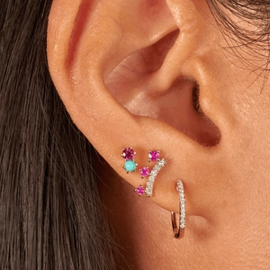 Detailed view of sterling silver crown studs with multi-color gemstones on ear