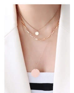 Close-up of triple-layered 18K gold plated titanium steel necklace with coin pendants