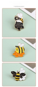Detailed close-up of three creative bee enamel pins featuring Michael text and cartoon designs