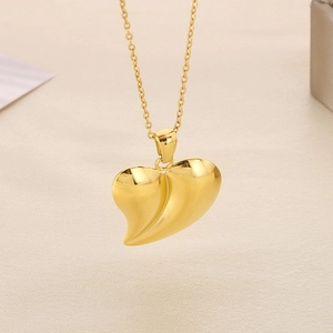 Macro shot of 3D gold heart pendant on O-chain necklace with smooth metallic finish