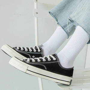 White cotton mid-calf socks with striped detail, paired with sneakers and blue denim jeans