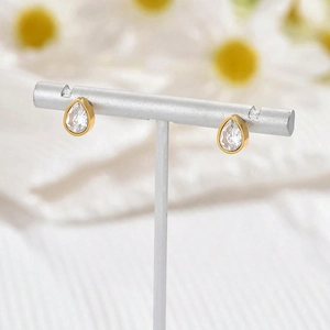 Elegant gold-plated stainless steel teardrop earrings with white zircon on a display stand