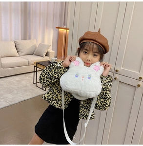 Detail of white plush rabbit crossbody bag with star embroidery on ears and soft texture
