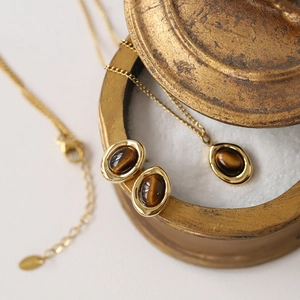 Detailed macro view of gold-plated tiger eye necklace and earrings set on vintage prop