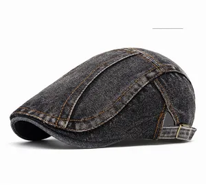 Detailed view of black washed denim ivy cap featuring orange contrast stitching and metal buckle