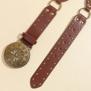 Détail d'une ceinture bohème vintage marron avec boucle en bronze et rivets en métal