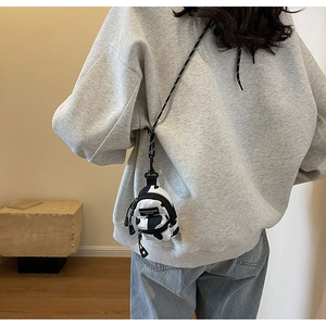 Rear view of mini crossbody bag with cow pattern print and adjustable cord strap
